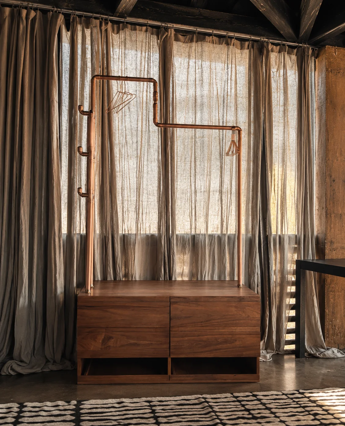 Casa Silencio: Escena editorial basada en las fotos originales · clóset móvil de madera y cobre.