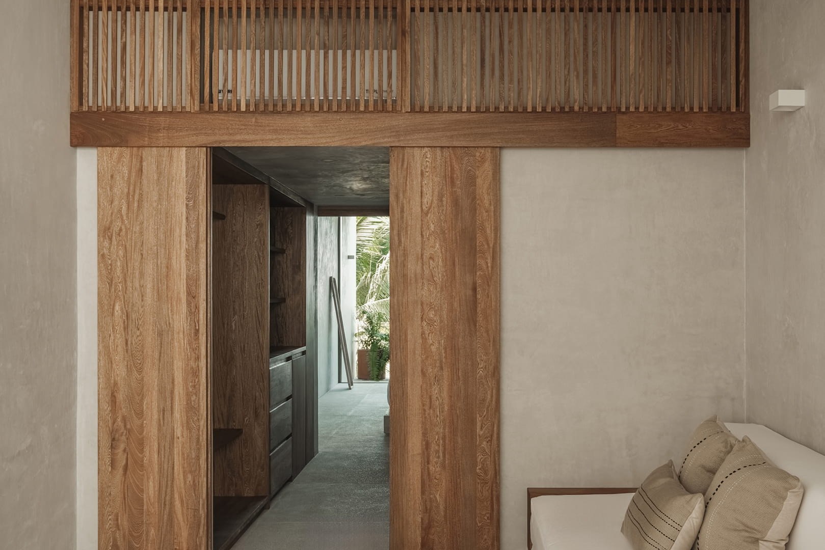 Hotel Notto: Paso entre habitaciones con puertas corredizas y celosía de madera.