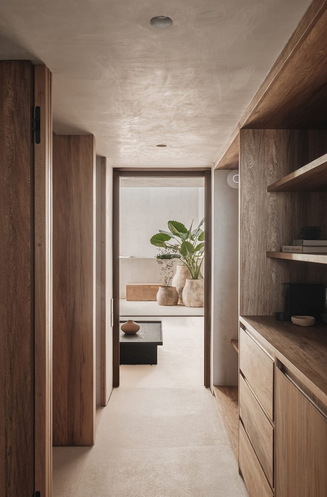 Hotel Notto: Pasillo con puertas y mobiliario empotrado de madera, abierto hacia un patio interior.