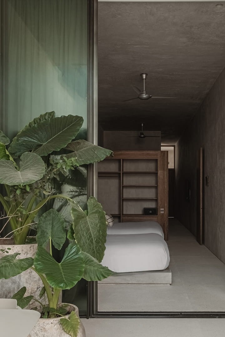 Hotel Notto: Habitación con cama baja y carpintería de madera, vista desde una terraza con plantas.