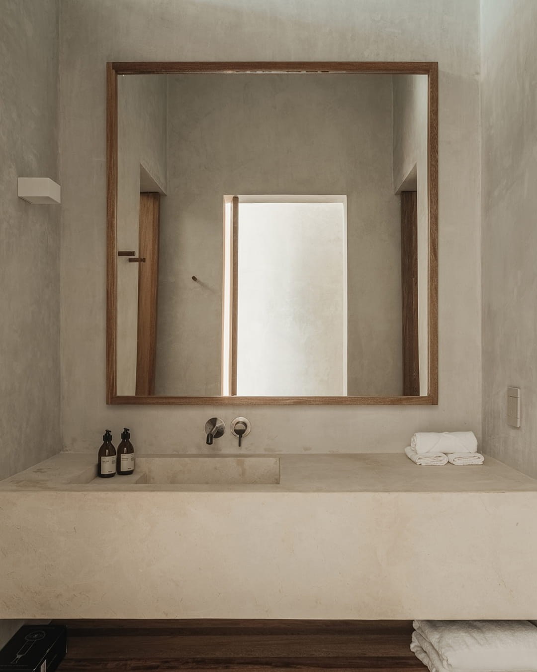 Hotel Notto: Lavabo de baño con espejo enmarcado, repisa y toallas.